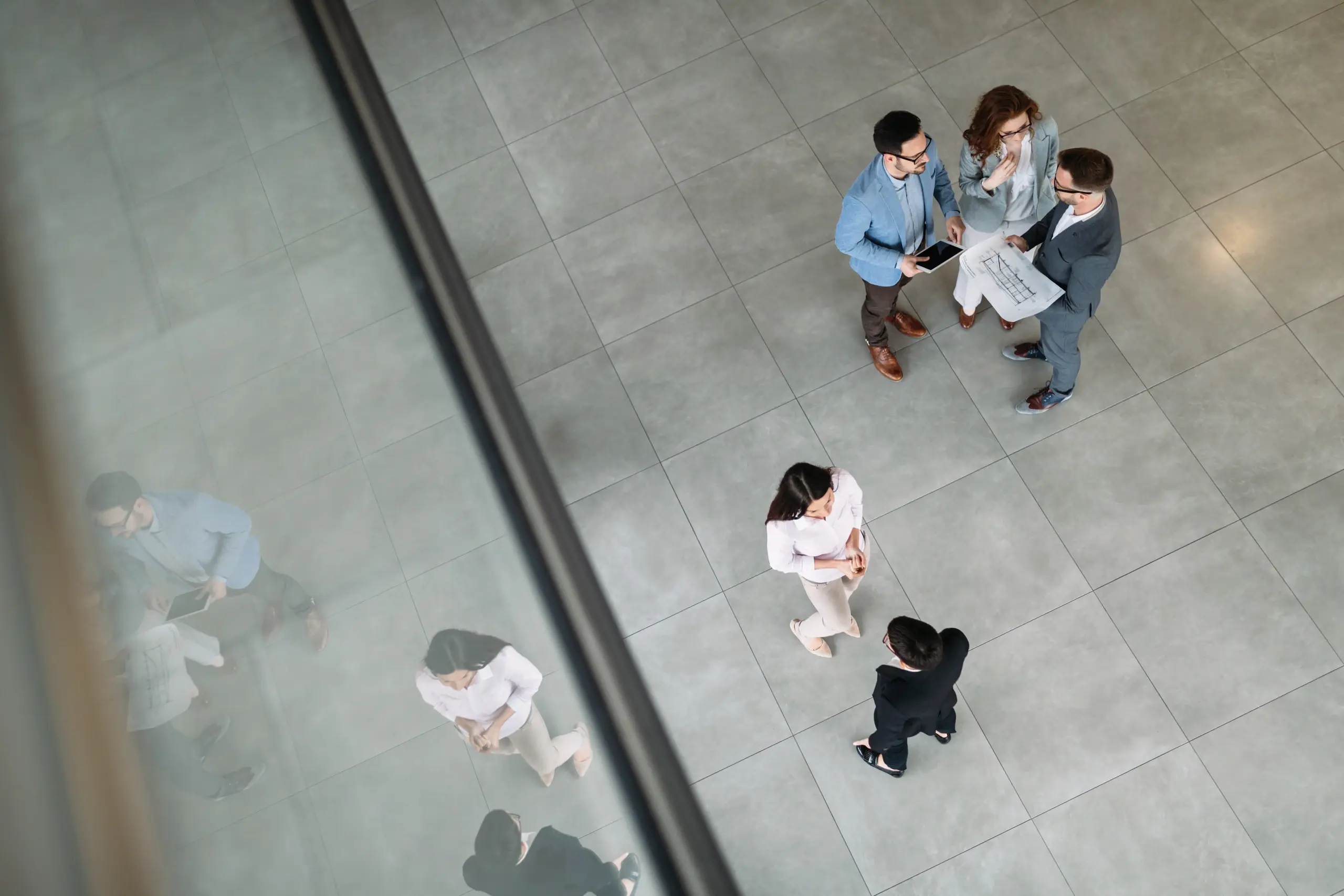 Colleagues meeting in an office atrium, viewed from above