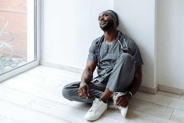 Tired doctor sitting on the floor