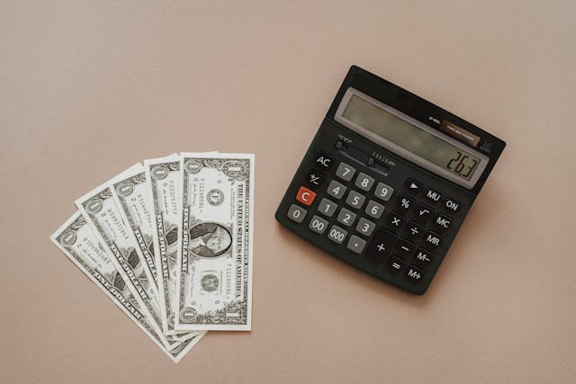 calculator next to dollar bills