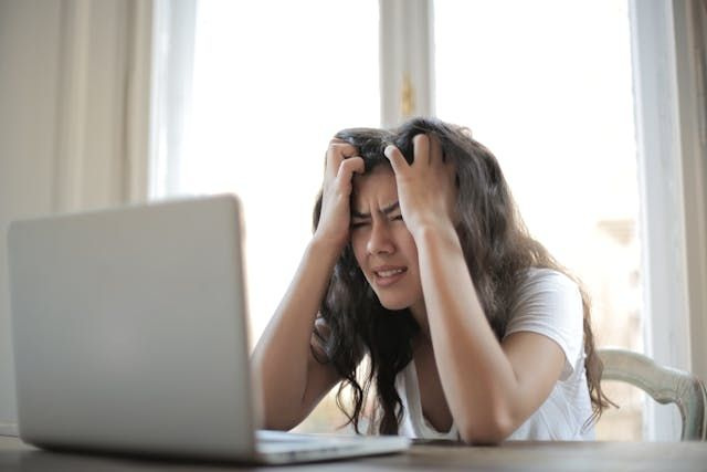 stressed person looking at laptop