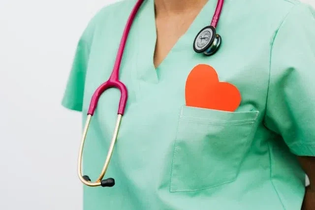 nurse with paper heart in pocket