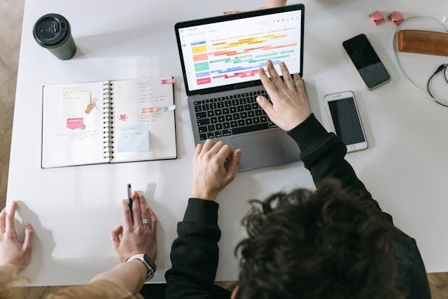 two co-workers at laptop scheduling