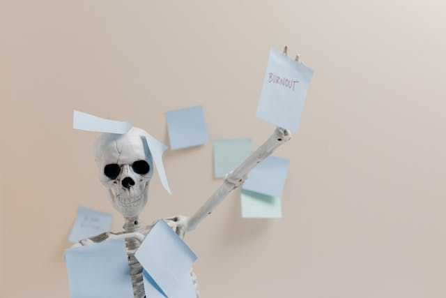 skeleton holding up sticky note which says burnout