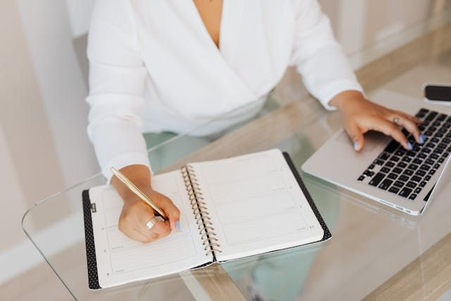 hospital administrator scheduling staff for shifts on laptop