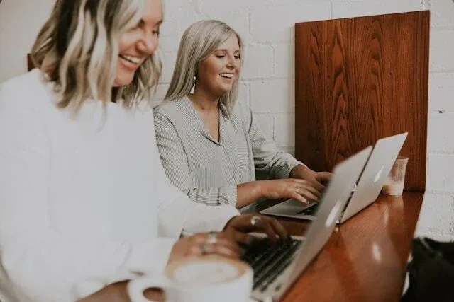 two happy workers at laptop