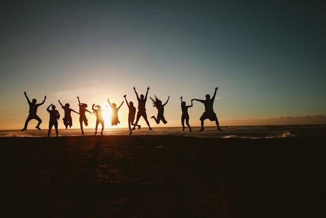 Happy team jumping together at the beach