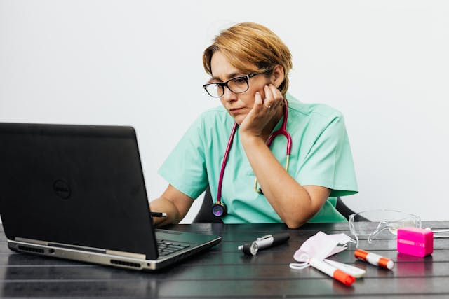 healthcare professional struggling at her laptop with shift swaps